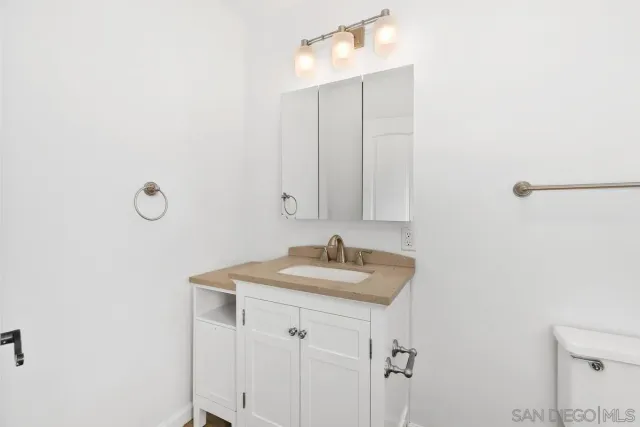 a bathroom with a granite countertop sink and mirror