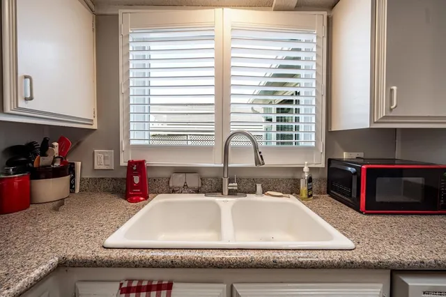 a bathroom with a granite countertop sink and a window