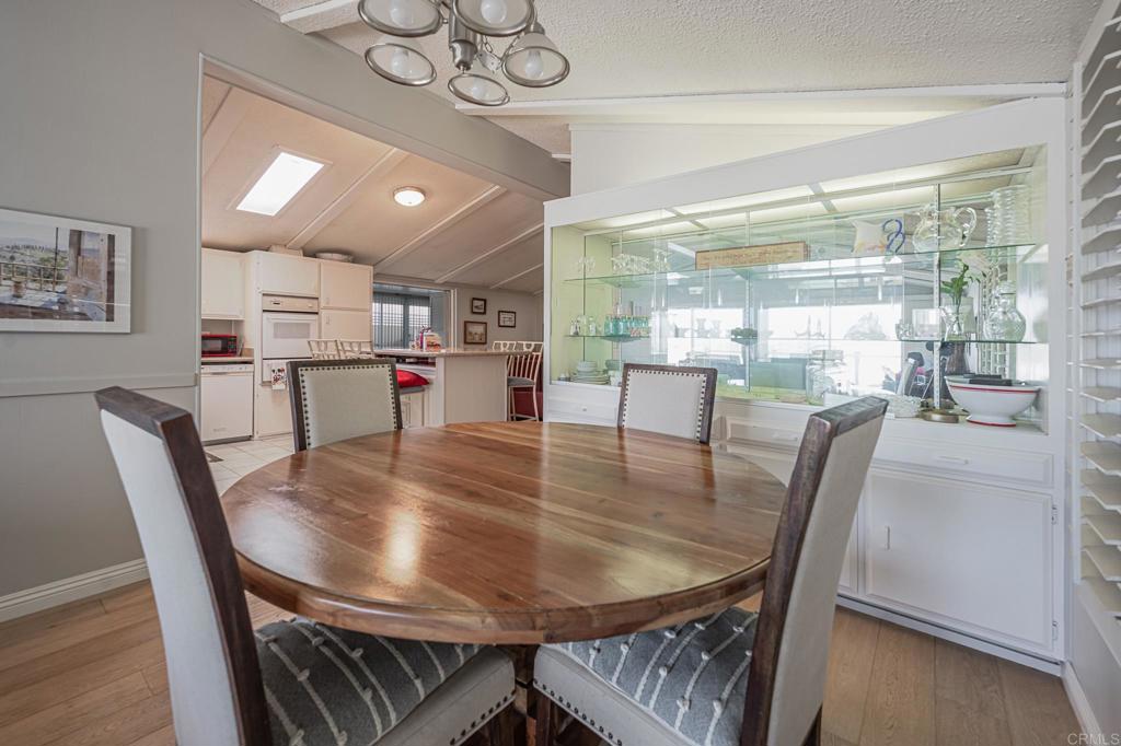 4650 Dulin Road, Unit 111 Fallbrook, CA 92003 - Photo 25 of 35 a dining room with furniture a chandelier and wooden floor