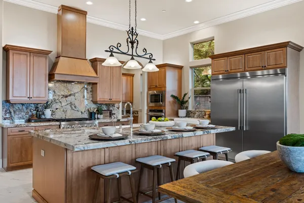 a kitchen with stainless steel appliances granite countertop a sink a stove and refrigerator