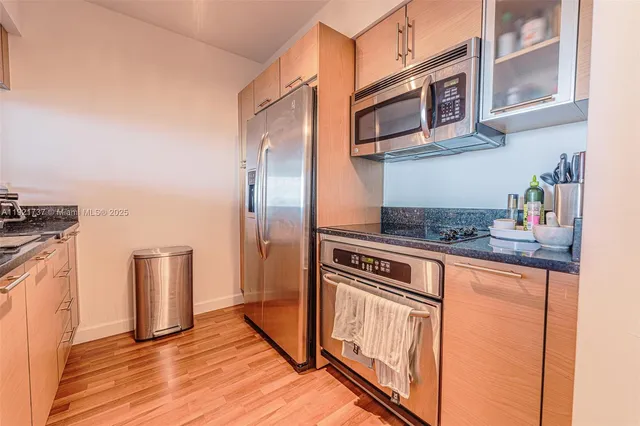 a kitchen with stainless steel appliances granite countertop a stove a refrigerator and a microwave