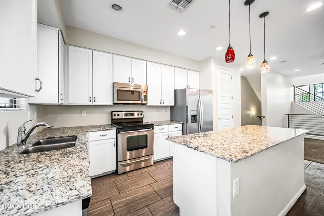 a kitchen with stainless steel appliances granite countertop a sink stove and microwave