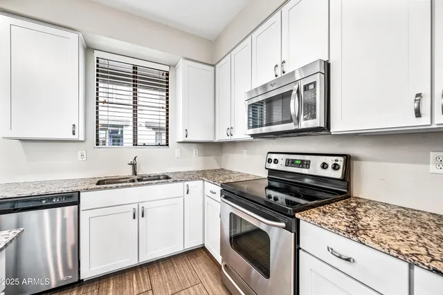 a kitchen with granite countertop a refrigerator and a sink