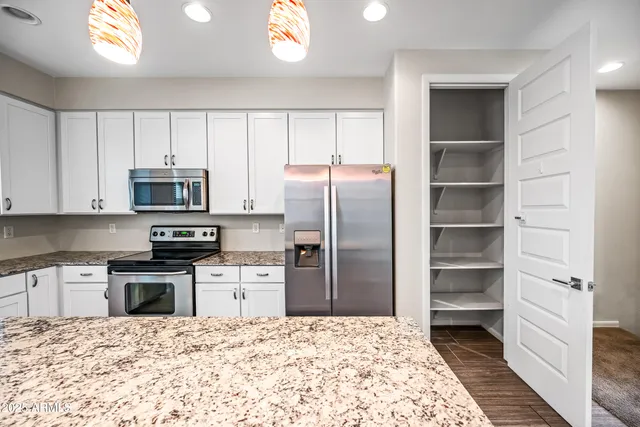 a kitchen with white cabinets and appliances