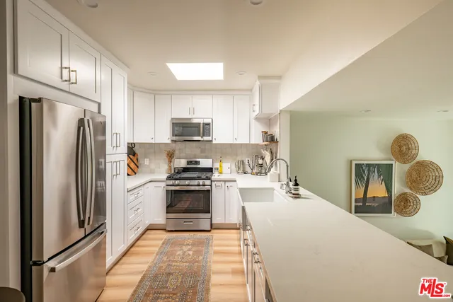 a kitchen with stainless steel appliances a refrigerator stove microwave and sink