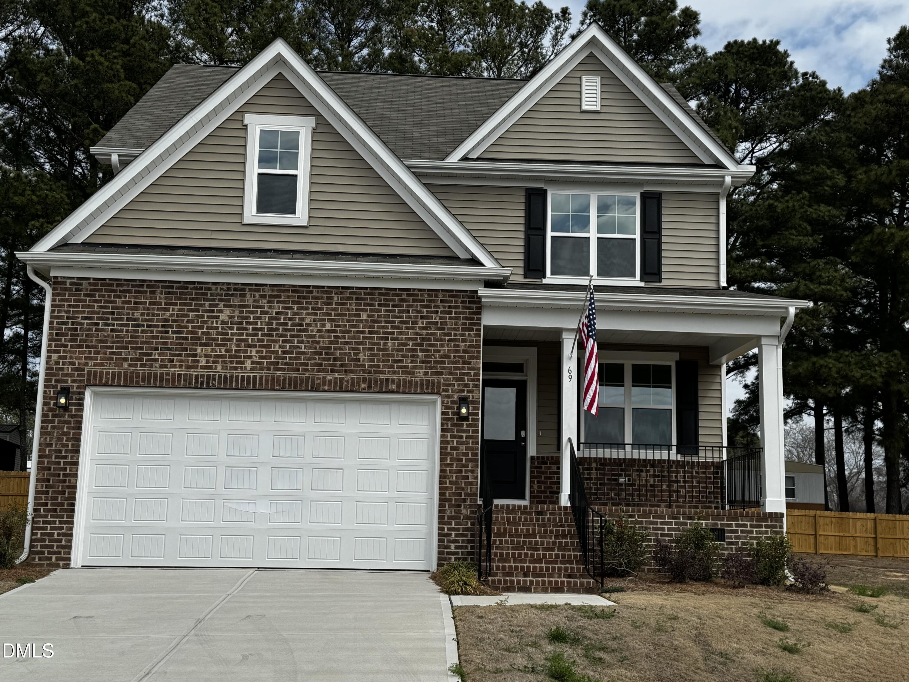 69 White Azalea Way Benson, NC 27504 - Photo 2 of 17 a front view of a house with garage