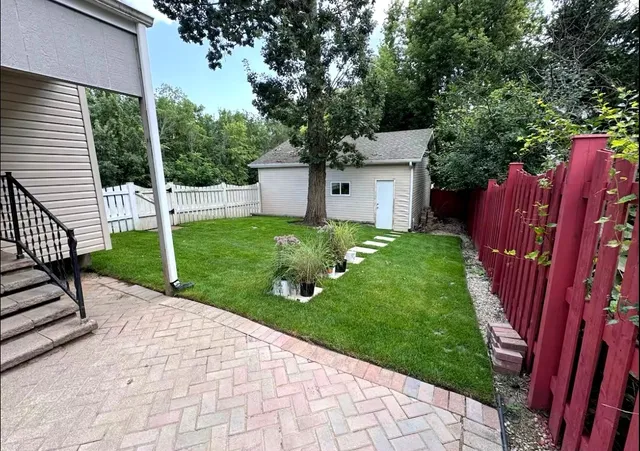 a view of a house with a yard and fence