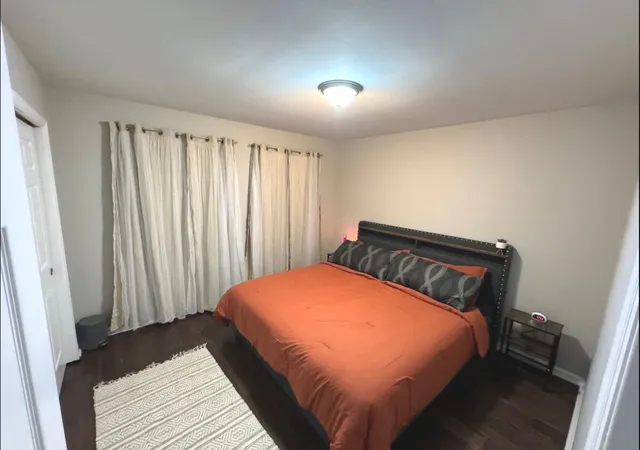 a bed sitting in a bedroom next to a window