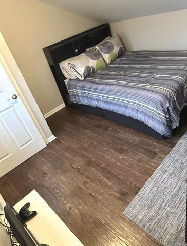 a view of bedroom with wooden floor