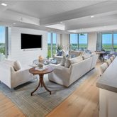 a living room with furniture a flat screen tv and a large window