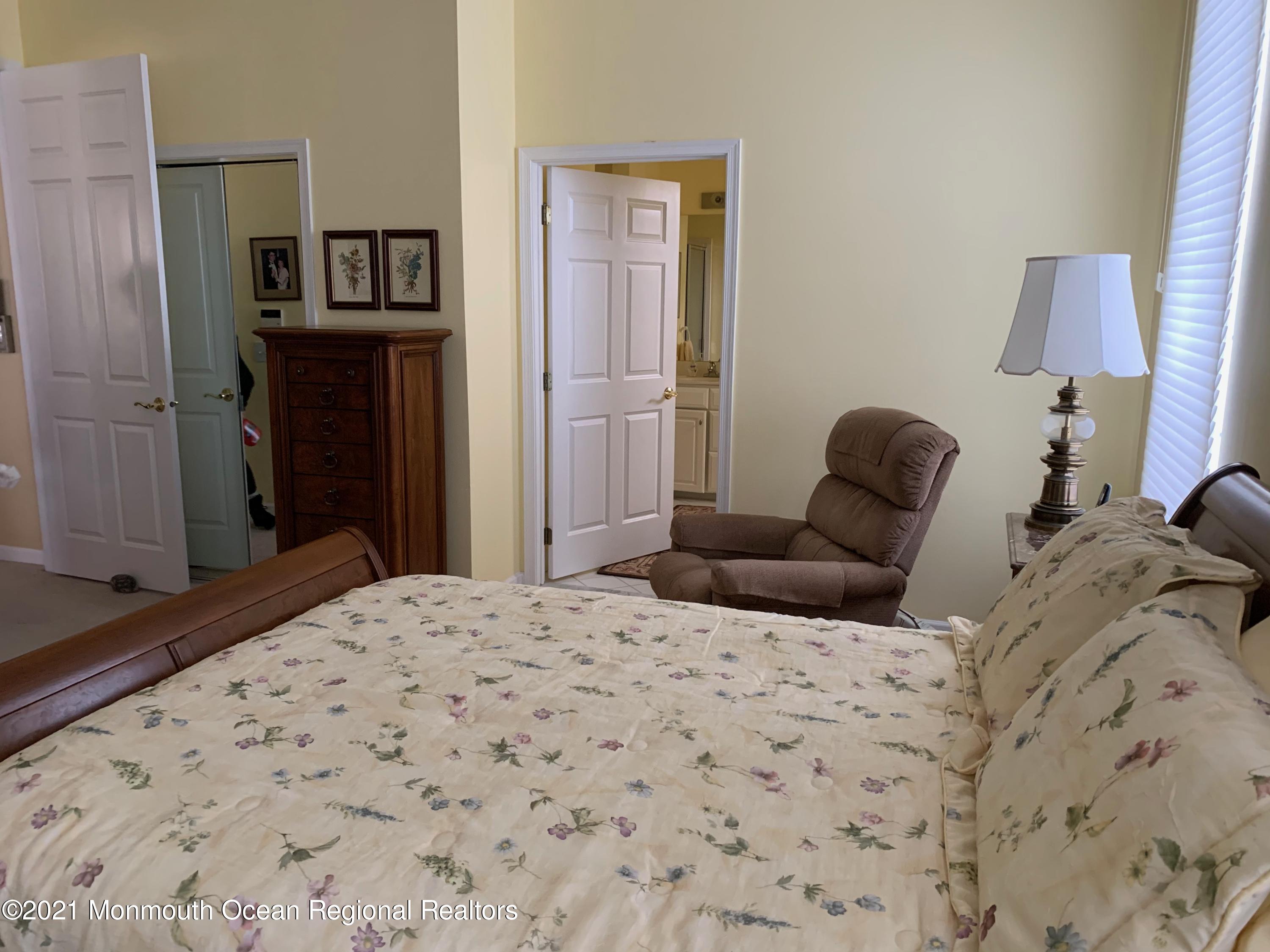 47 Shoal Road Jackson, NJ 08527 - Photo 40 of 56 a bedroom with a bed and a lamp