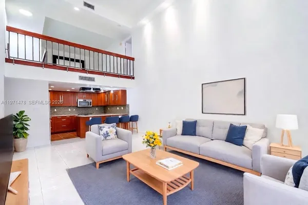 a living room with furniture and a book shelf