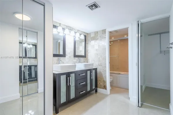 a bathroom with a double vanity sink mirror and shower