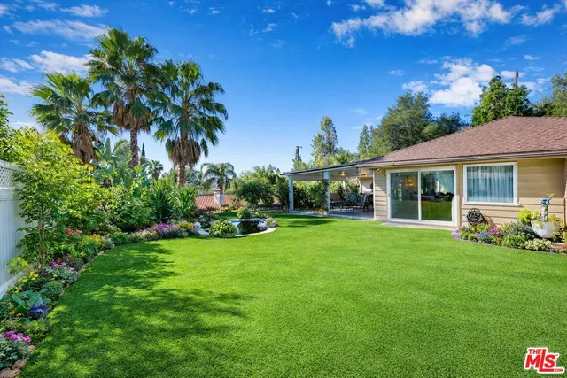 a view of a house with backyard sitting area and garden