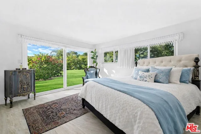 a bed sitting in a bedroom next to a window