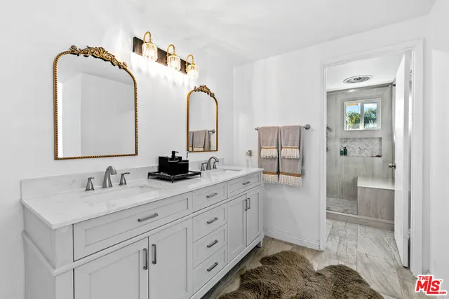 a en suite bathroom with a double vanity sink and a mirror