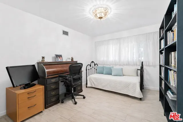 a bedroom with a workspace and a couch