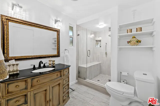 a bathroom with a granite countertop sink toilet and shower