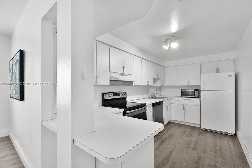 1051 Meridian Avenue, Unit 1C Miami Beach, FL 33139 - Photo 3 of 27 a kitchen with white cabinets and white appliances