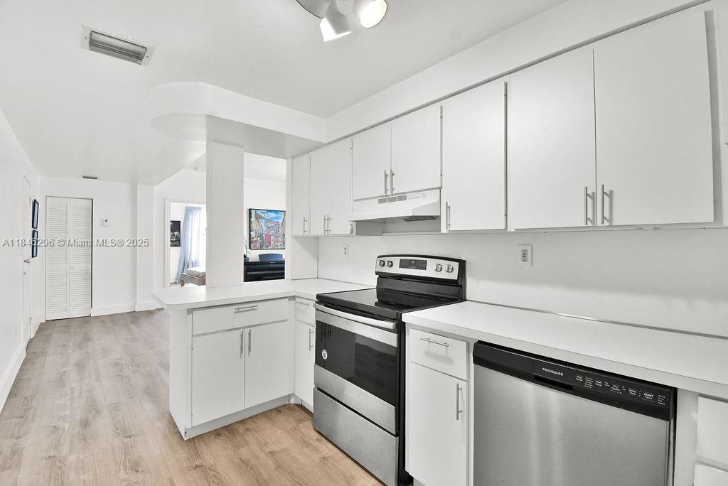 1051 Meridian Avenue, Unit 1C Miami Beach, FL 33139 - Photo 8 of 27 a kitchen with white cabinets and white appliances
