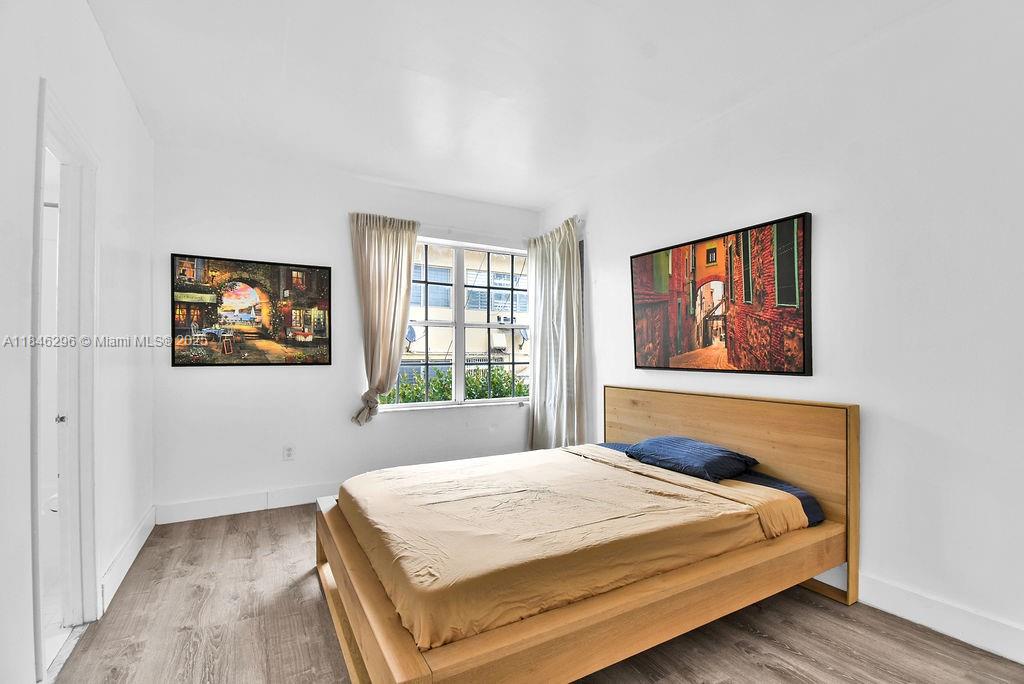 1051 Meridian Avenue, Unit 1C Miami Beach, FL 33139 - Photo 9 of 27 a bedroom with a bed and a painting on the wall