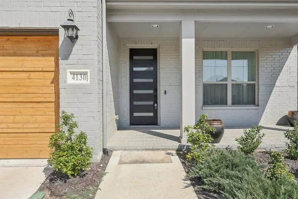 front view of a house with a potted plant and windows