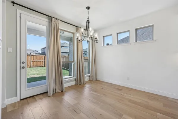 a view of a room with wooden floor large mirror and windows
