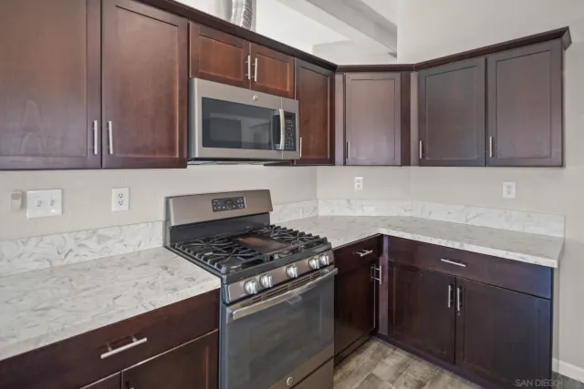 a kitchen with granite countertop cabinets and steel stove top oven