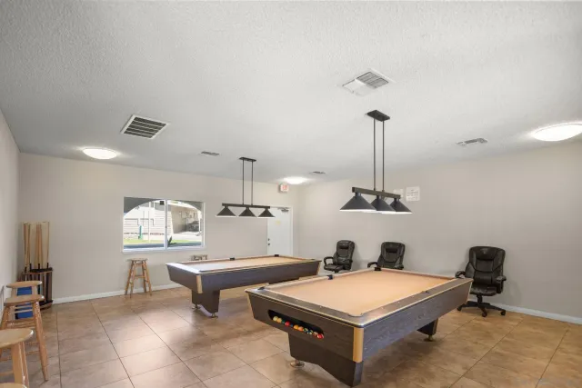 a view of a swimming pool with a yard and large trees