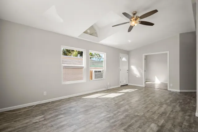 a large kitchen with cabinets wooden floor and a ceiling fan