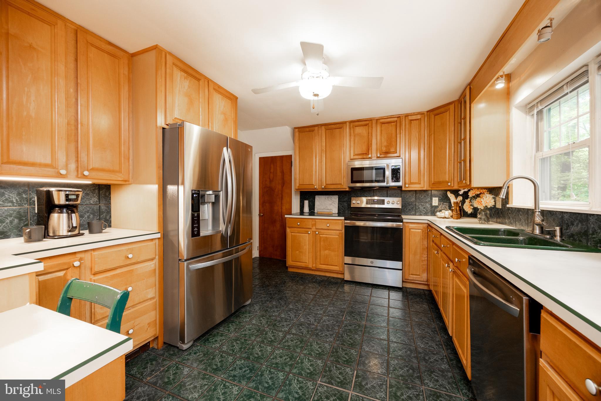 337 Greene Road Berwyn, PA 19312 - Photo 10 of 35 a kitchen with granite countertop a refrigerator and a stove top oven