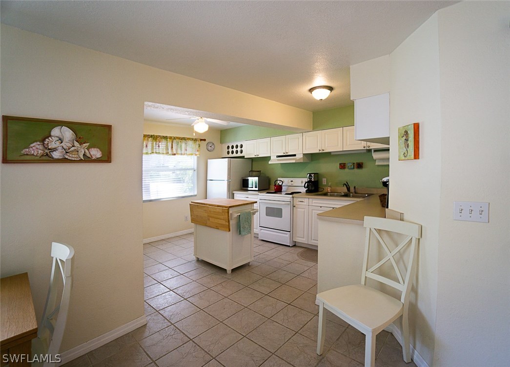 849 Beach Road Sanibel, FL 33957 - Photo 5 of 14 a living room with furniture a dining table and kitchen view with wooden floor