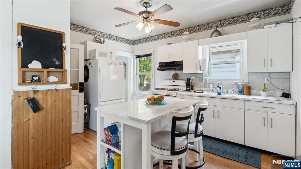 80 Union Avenue Little Ferry, NJ 07643 - Photo 7 of 35 a kitchen with stainless steel appliances granite countertop a refrigerator a sink dishwasher a dining table and chairs with wooden floor