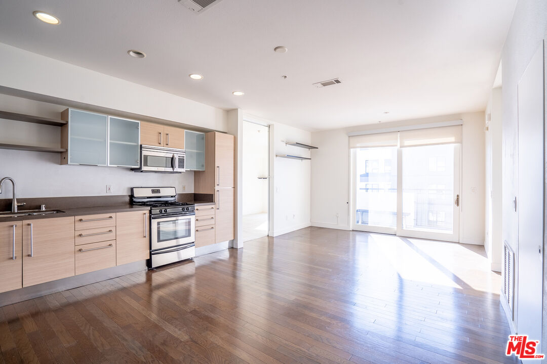 1234 Wilshire Boulevard, Unit 517 Los Angeles, CA 90017 - Photo 3 of 17 a kitchen with stainless steel appliances granite countertop a stove top oven a sink and a refrigerator
