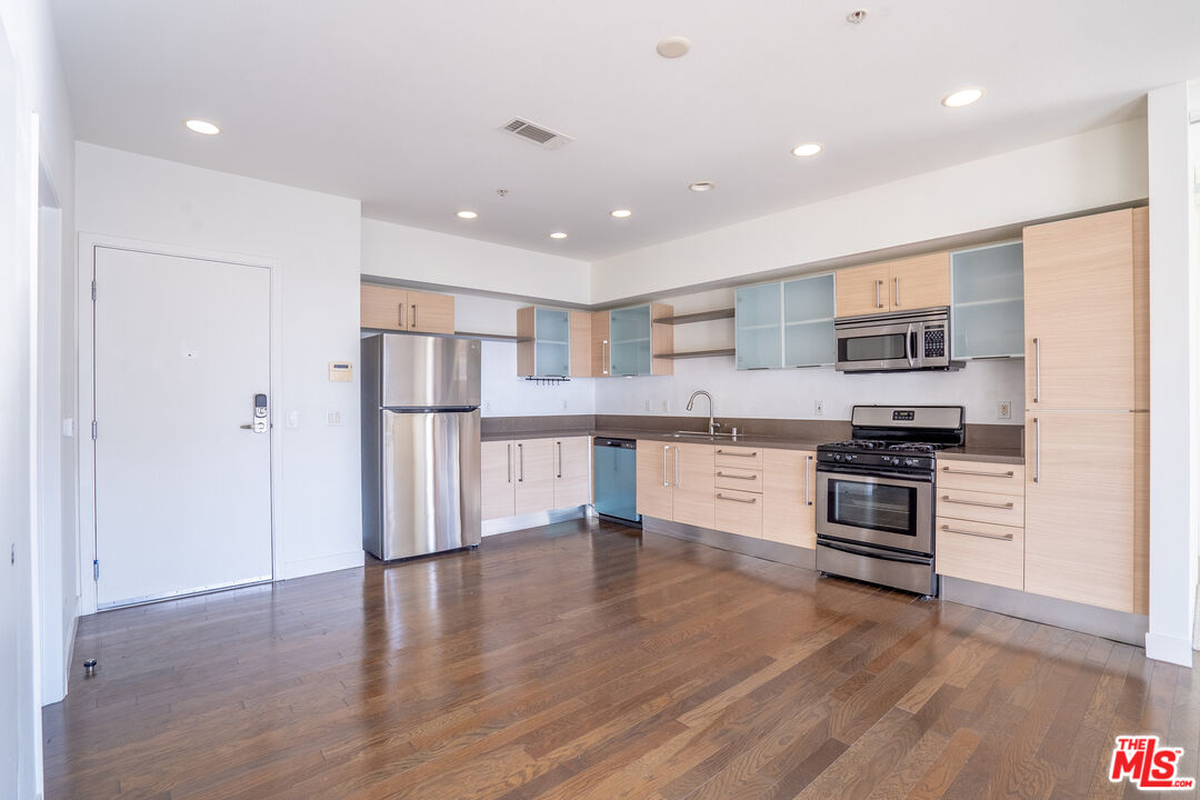 1234 Wilshire Boulevard, Unit 517 Los Angeles, CA 90017 - Photo 4 of 17 a kitchen with stainless steel appliances granite countertop a refrigerator and a stove top oven