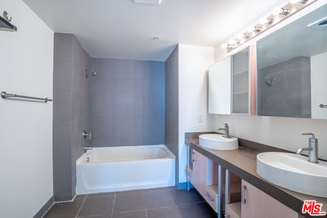 1234 Wilshire Boulevard, Unit 517 Los Angeles, CA 90017 - Photo 9 of 17 a bathroom with a granite countertop tub sink and mirror