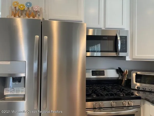 a kitchen with stainless steel appliances granite countertop a refrigerator and a stove