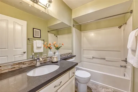 a bathroom with a granite countertop sink toilet and shower