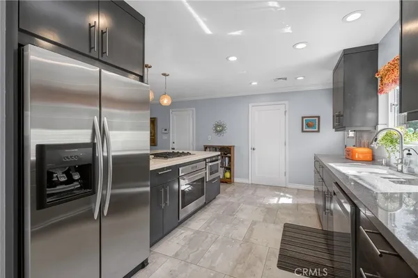 a kitchen with stainless steel appliances granite countertop a sink and a refrigerator