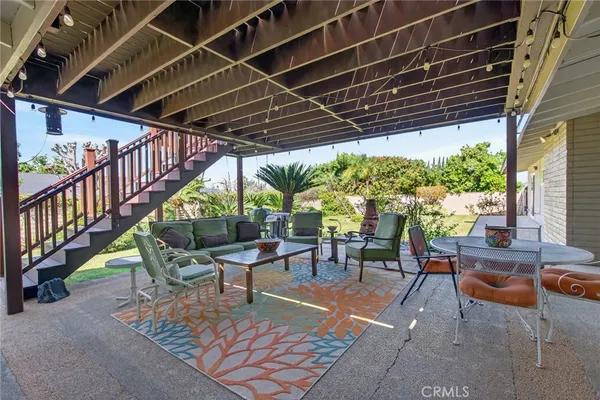 a patio with glass top table and chairs