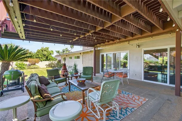 a living room with patio furniture and a potted plant