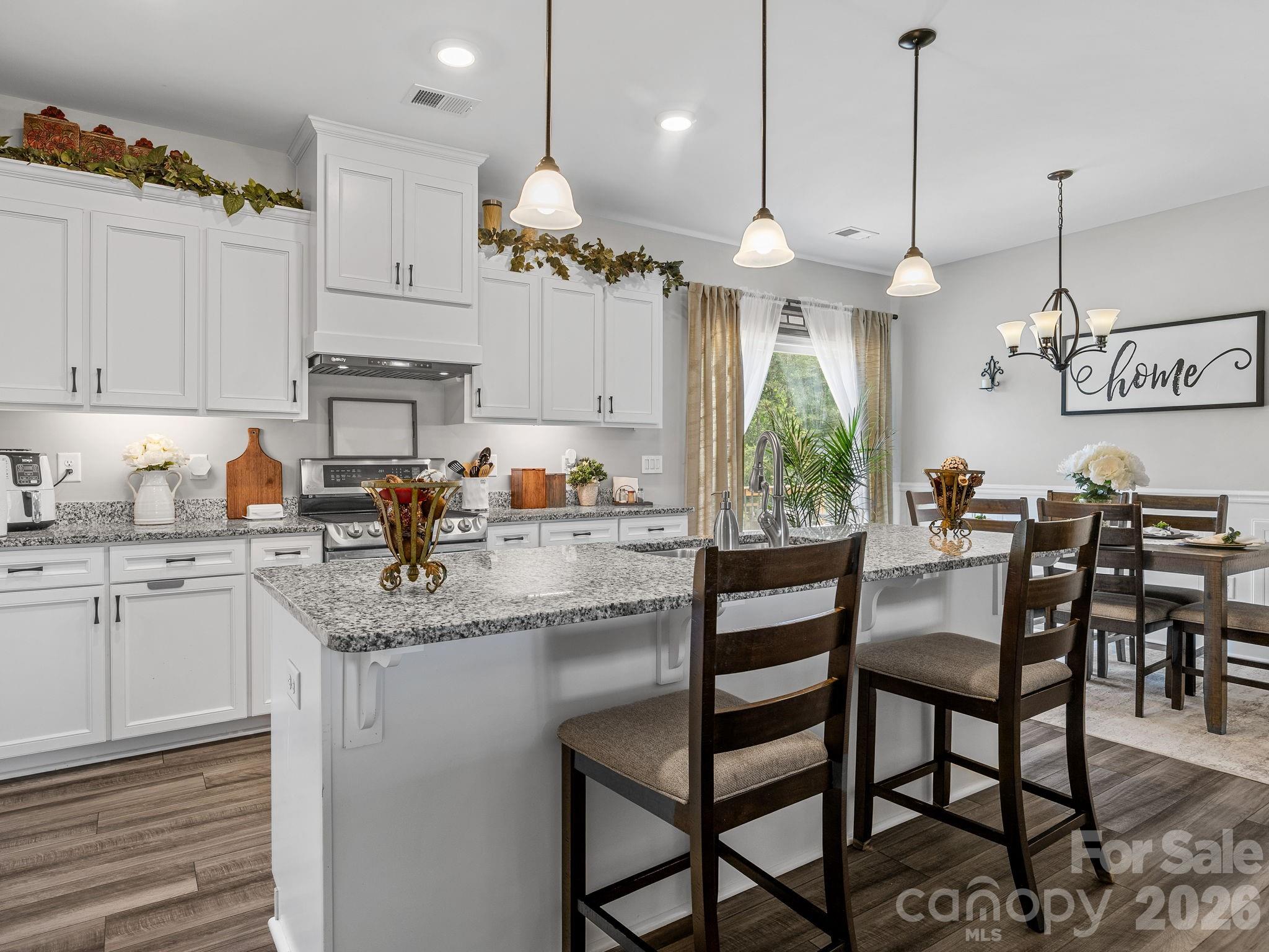 1076 McSwain Road Chesnee, SC 29323 - Photo 10 of 36 a kitchen with stainless steel appliances granite countertop a stove a sink and a refrigerator with wooden floor