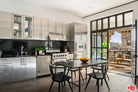 a kitchen with a table chairs refrigerator and cabinets