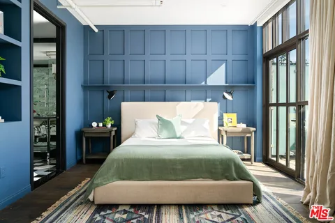 a bed sitting in a bedroom next to a window