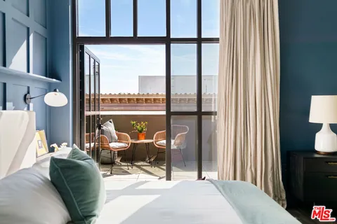 a living room filled with furniture and a floor to ceiling window