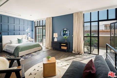 a bedroom with a bed mirror and a window