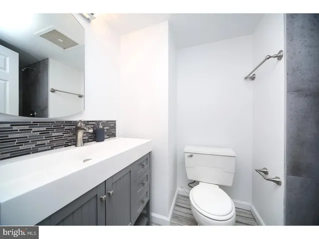 a bathroom with a toilet sink a mirror and vanity
