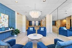 a living room with furniture chandelier and a view of kitchen