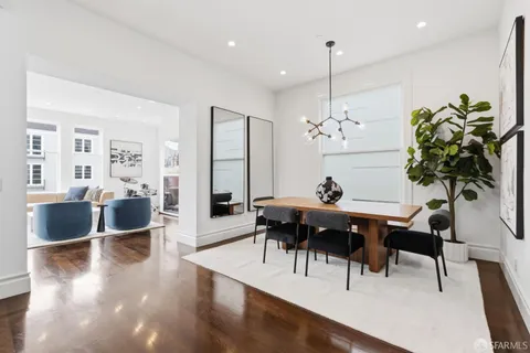 a living room with furniture kitchen view and a large window
