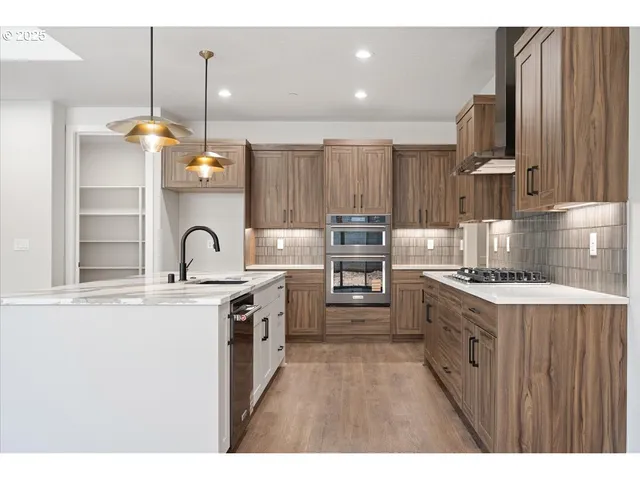 a kitchen with stainless steel appliances granite countertop a stove a sink dishwasher and a refrigerator